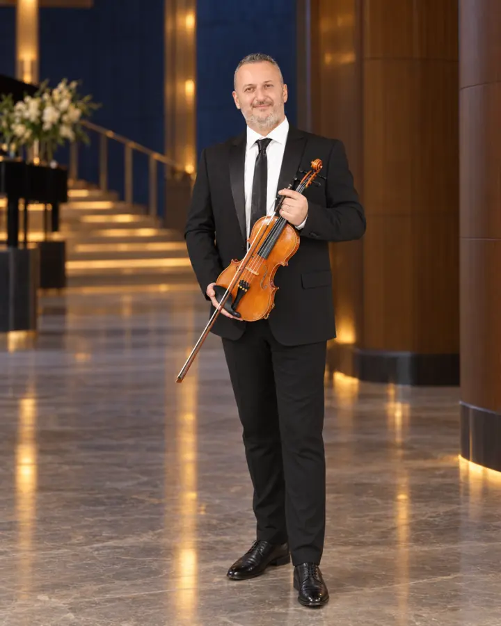 Paolo Castellani in concert attire holding his violin